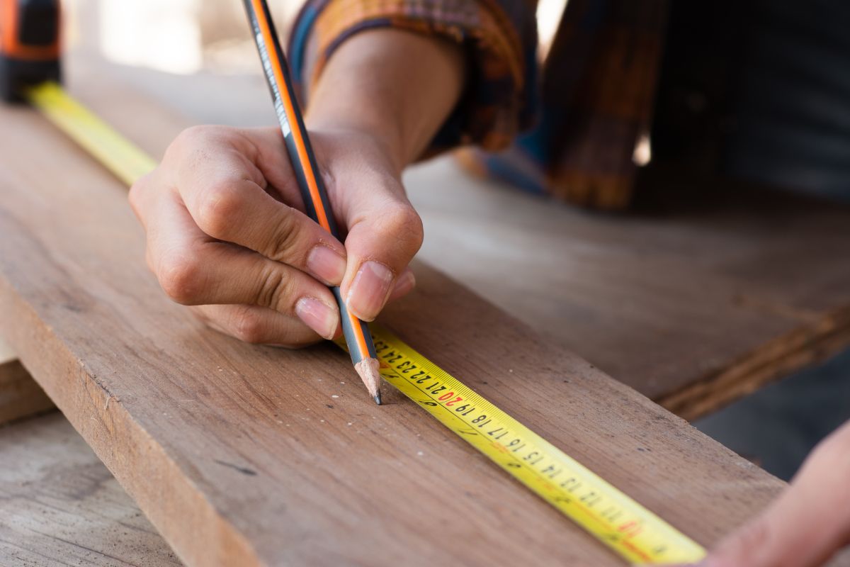 Person measuring a wood board